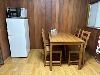 a kitchen with a table and a microwave and a refrigerator at Vivian house in Tokyo