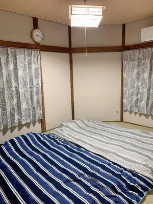 a bedroom with a bed with blue and white stripes at Vivian house in Tokyo