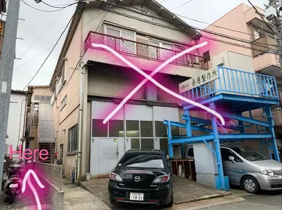 a car parked in front of a building with pink graffiti at Vivian house in Tokyo