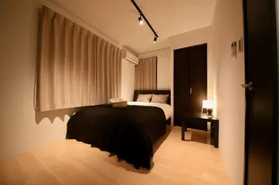 a bedroom with a black bed and a window at CORDEA\u516b\u5e83 in Tokyo