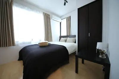 a bedroom with a bed and a table and a window at CORDEA\u516b\u5e83 in Tokyo