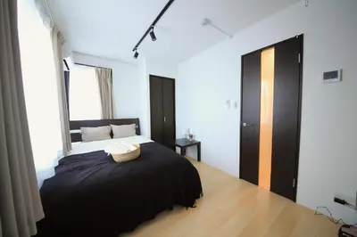 a bedroom with a bed with a black blanket at CORDEA\u516b\u5e83 in Tokyo