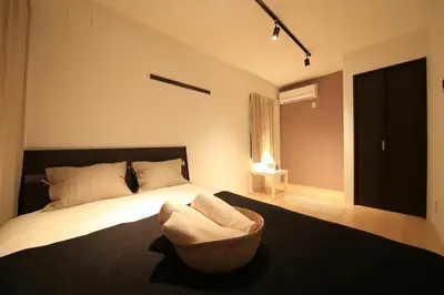 a bedroom with a bed with a chair and a window at CORDEA\u516b\u5e83 in Tokyo