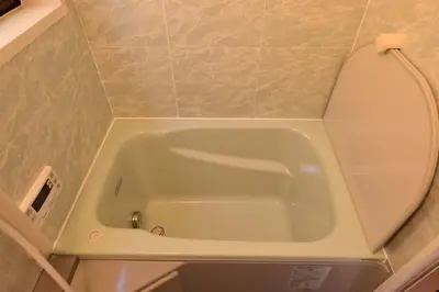 a bathroom with a tub with a mirror on the wall at OMM STAY in Tokyo