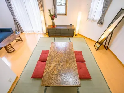 a living room with a wooden table on a rug at Katsushika Takasago House in Tokyo