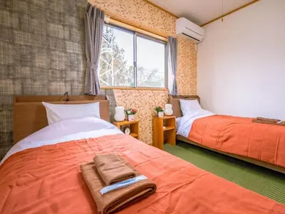 a bedroom with two beds and a window at Katsushika Takasago House in Tokyo