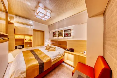 a small bedroom with a bed and a red chair at HOTEL Lotus Shibuya (Adult Only) in Tokyo