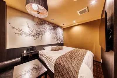 a bedroom with a bed and a painting on the wall at HOTEL Lotus Ikebukuro (Adult Only) in Tokyo