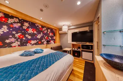 a bedroom with a large bed and a television at HOTEL Lotus Ikebukuro (Adult Only) in Tokyo