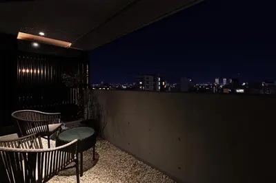 a table and chairs on a balcony at night at PROSTYLE RYOKAN TOKYO ASAKUSA in Tokyo