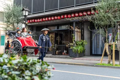 a man pulling a carriage with a family at PROSTYLE RYOKAN TOKYO ASAKUSA in Tokyo