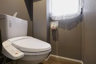 a bathroom with a white toilet with a window at Akabane TK Building 101 in Tokyo