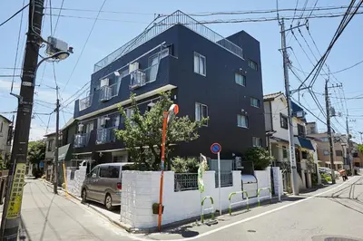 a blue building on the side of a street at Akabane TK Building 101 in Tokyo