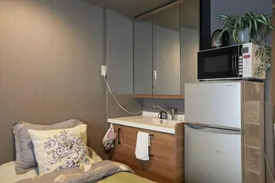 a small kitchen with a refrigerator and a sink at Akabane TK Building 102 in Tokyo