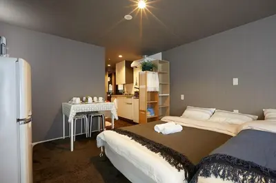 a room with two beds and a table and a kitchen at Akabane TK Building 103 in Tokyo