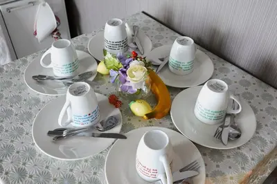a table with white plates and cups and flowers on it at Akabane TK Building 103 in Tokyo