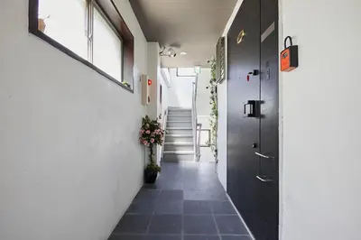 a hallway with a staircase and a vase of flowers at Akabane TK Building 103 in Tokyo