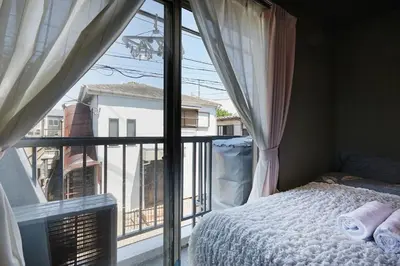 a bedroom with a bed and a large window at Akabane TK Building 201 in Tokyo