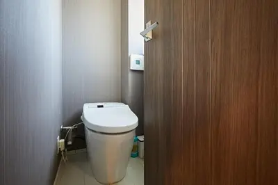 a bathroom with a toilet and a wooden door at Akabane TK Building 201 in Tokyo