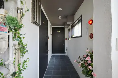 a hallway with plants on the walls and a door at Akabane TK Building 201 in Tokyo