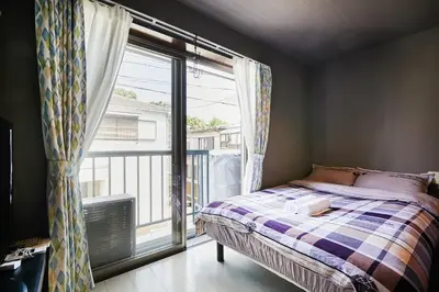 a bedroom with a bed and a large window at Akabane TK Building 202 in Tokyo
