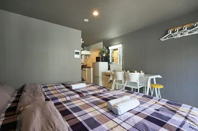 a bedroom with a bed and a kitchen with a table at Akabane TK Building 202 in Tokyo