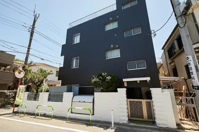 a black building with a bench in front of it at Akabane TK Building 202 in Tokyo