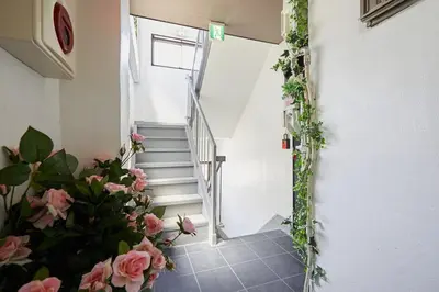 a stairway with pink flowers in a room at Akabane TK Building 202 in Tokyo