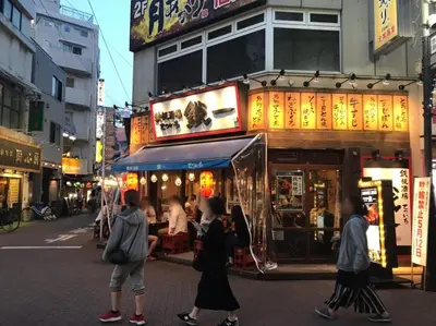 a group of people standing in front of a restaurant at Akabane TK Building 202 in Tokyo