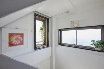 a white room with two windows and a picture at Akabane TK Building 203 in Tokyo