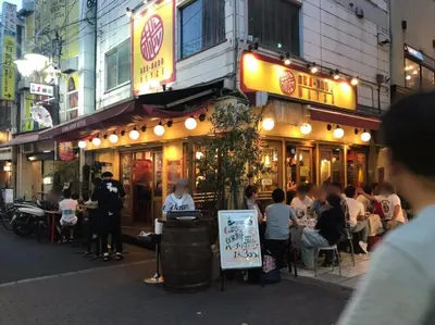 a group of people sitting outside of a restaurant at Akabane TK Building 203 in Tokyo