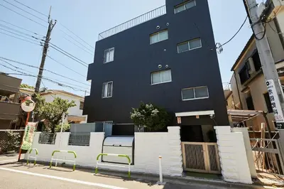 a black building with a bench in front of it at Akabane TK Building 301 in Tokyo