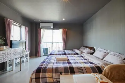 a bedroom with a large bed with a plaid blanket at Akabane TK Building 301 in Tokyo