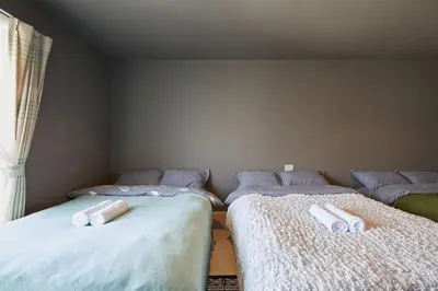 two beds in a room with white sheets at Akabane TK Building 302 in Tokyo