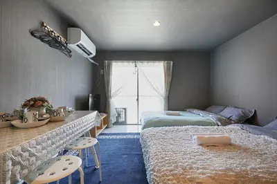 a bedroom with two beds and a table and chairs at Akabane TK Building 302 in Tokyo