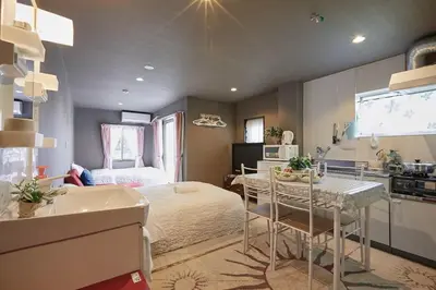 a bedroom with a bed and a table and a kitchen at Akabane TK Building 303 in Tokyo