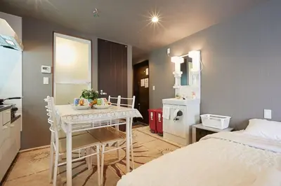 a room with a bed and a table with chairs at Akabane TK Building 303 in Tokyo