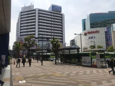 a city street with a bus stop and buildings at Akabane TK Building 303 in Tokyo