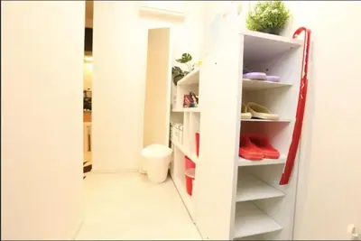 a hallway with white shelves and red shoes at Kamiya TK Building 201 in Tokyo