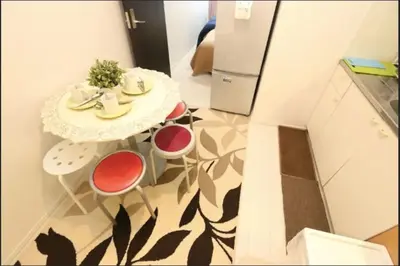 a kitchen with a table and a cat sitting on the floor at Kamiya TK Building 201 in Tokyo
