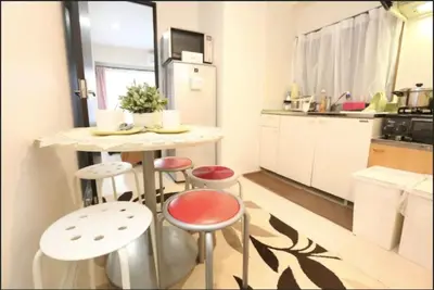 a small kitchen with a table and stools at Kamiya TK Building 201 in Tokyo