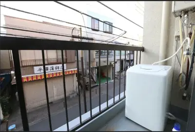 a white refrigerator on a balcony of a building at Kamiya TK Building 201 in Tokyo