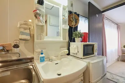 a bathroom with a sink and a microwave at Kamiya TK Building 203 in Tokyo
