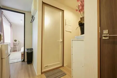 a hallway with a door to a room with a refrigerator at Kamiya TK Building 203 in Tokyo