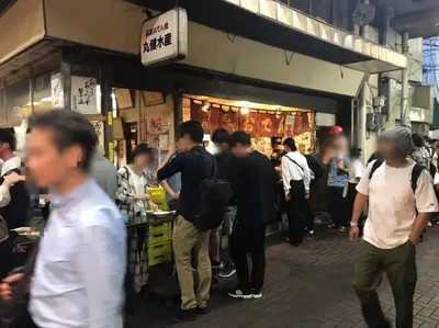 a crowd of people standing outside of a store at Kamiya TK Building 203 in Tokyo