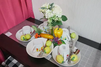 a table with plates of vegetables and a vase of flowers at Kamiya TK Building 301 in Tokyo