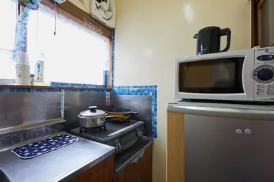 a kitchen with a microwave oven and a stove at Kamiya TK Building 301 in Tokyo