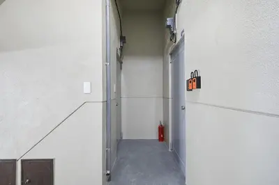 an empty hallway with a fire extinguisher sign on the wall at Kamiya TK Building 301 in Tokyo