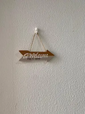 a sign hanging on a white wall at Takemura Building 302 in Tokyo