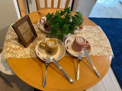 a table with plates and utensils and a plant on it at Takemura Building 302 in Tokyo